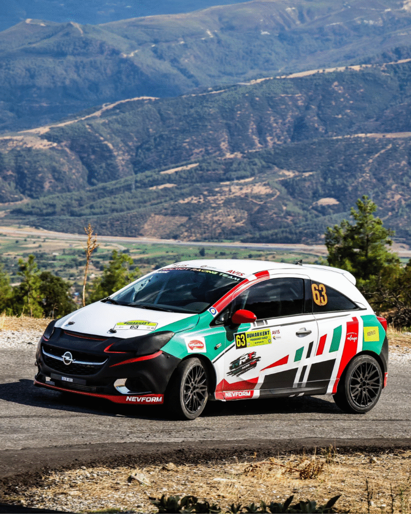 Rolmot Racing Team Opel Corsa rally car racing on a mountain road during Turkish hill climb rally with scenic valley view